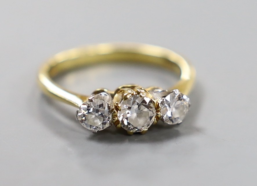 A modern 18ct gold and three stone set diamond ring, size K/L, gross weight 3 grams.